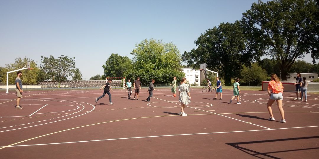 Des jeunes de LaMano jouent au foot sur le plateau sportif de Nozay